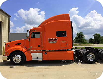 A red Ditzfeld transportation truck parked in the sun